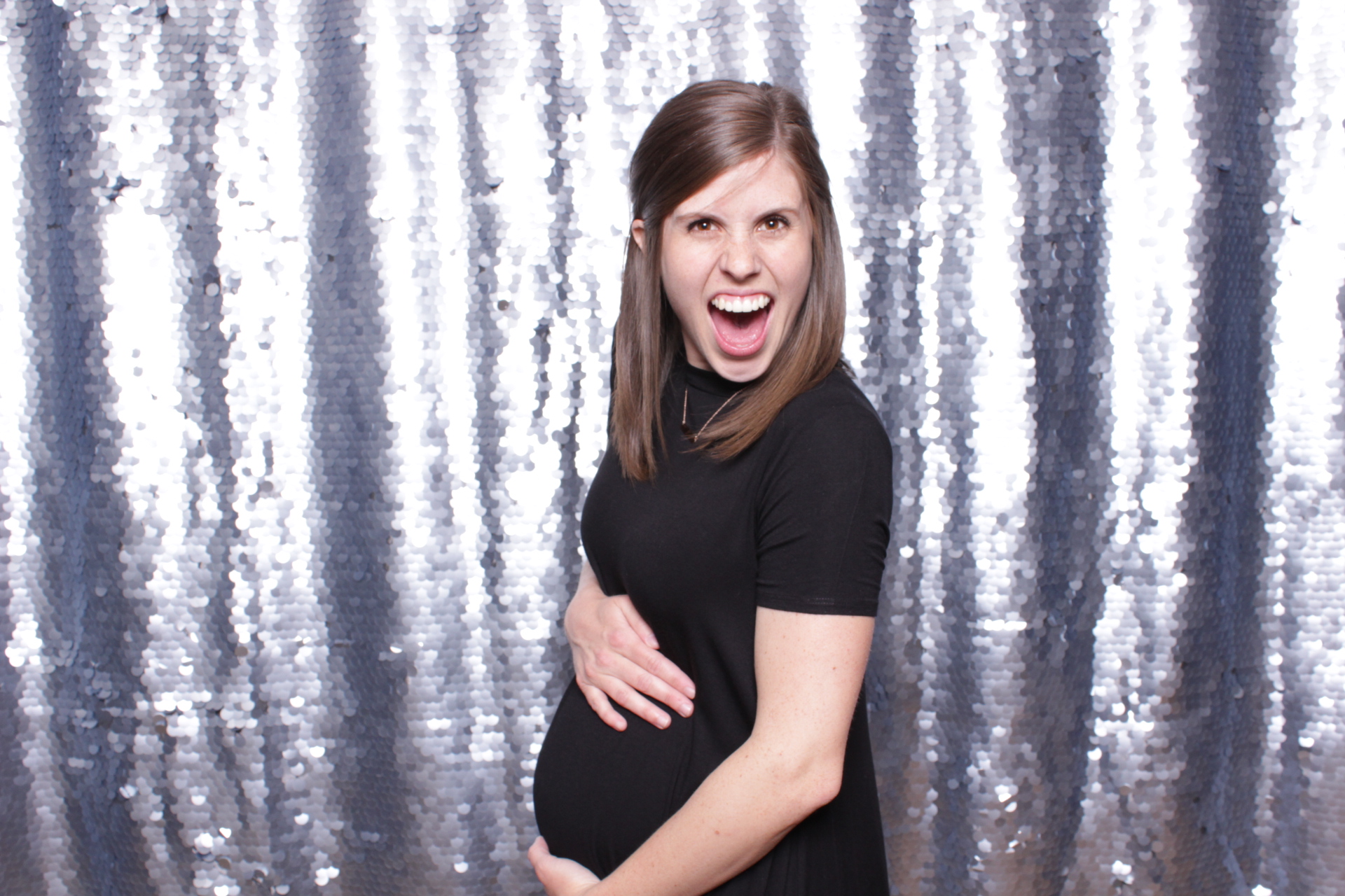 pregnant woman poses in a photo booth