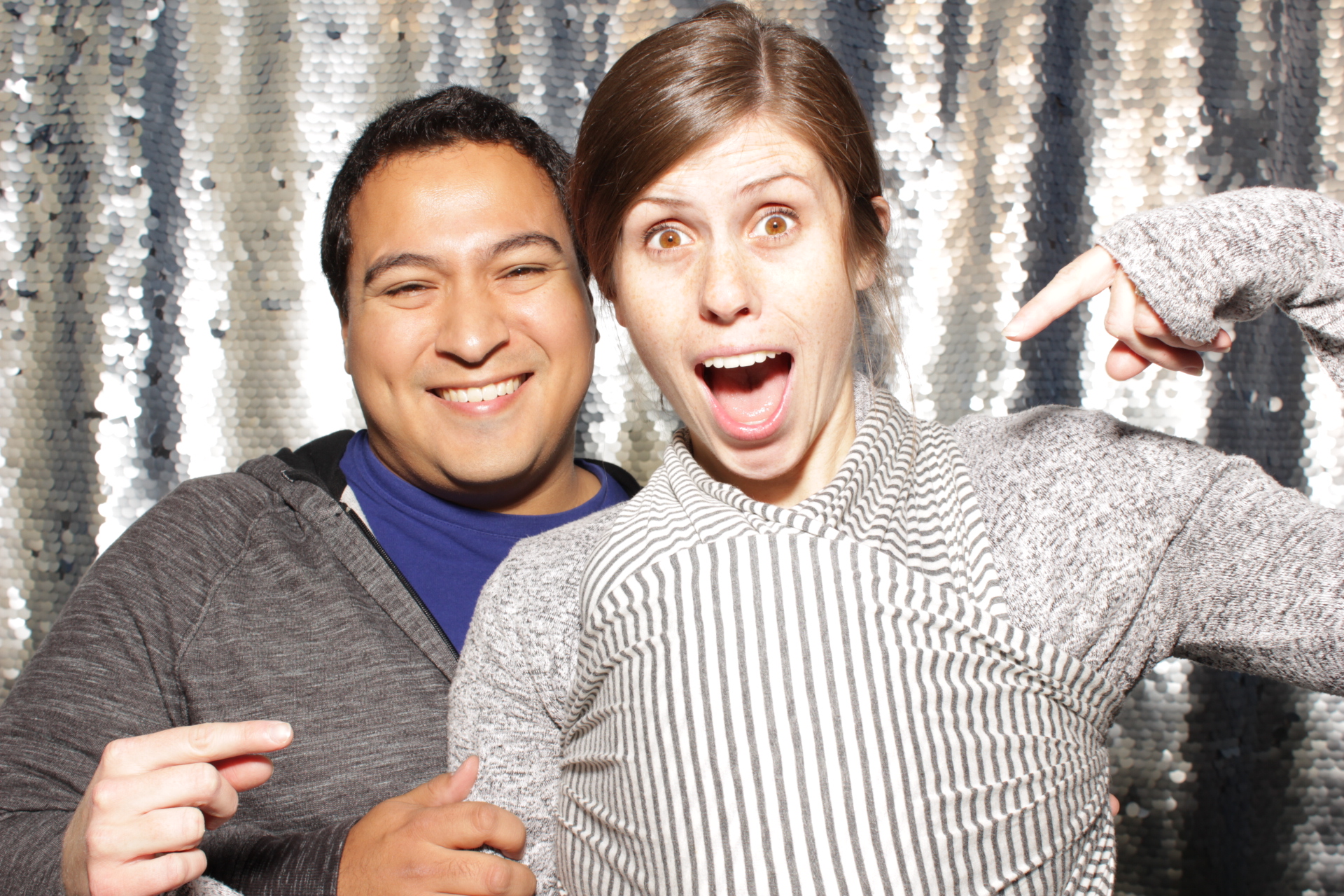 parents pose in photo booth with their newborn